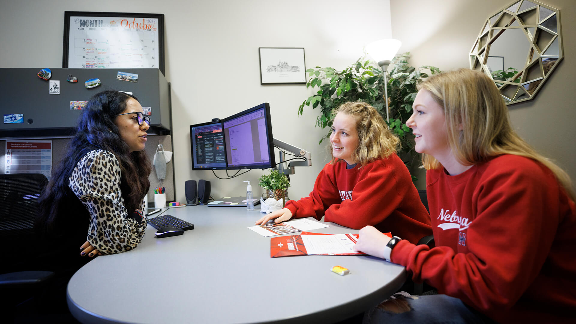 Students talking with advisor in office